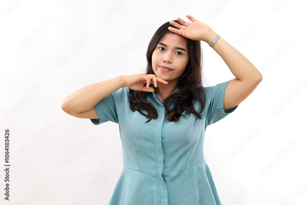 Horizontal shot of sensual tender Asian woman with dark hair touches face looks directly at camera wears casual shirt poses against white background has natural beauty. Feminine concept. Horizontal shot of sensual tender Asian woman with dark hair touches face looks directly at camera wears casual shirt poses against white background has natural beauty. Feminine concept.