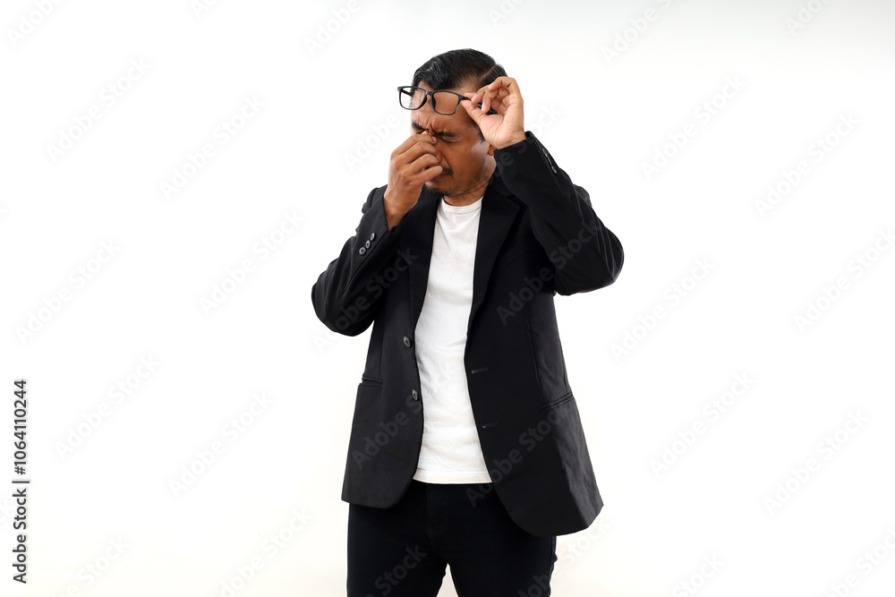 Tired Asian Businessman standing while rubbing his eyes, isolated on white background Tired Asian Businessman standing while rubbing his eyes, isolated on white background