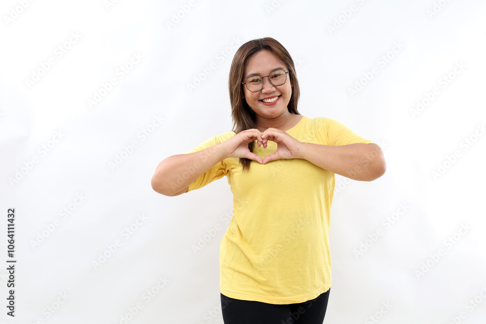 Lovely Asian woman with happy smile, shapes heart with both hands, expresses love to you. Isolated on white background Lovely Asian woman with happy smile, shapes heart with both hands, expresses love to you. Isolated on white background