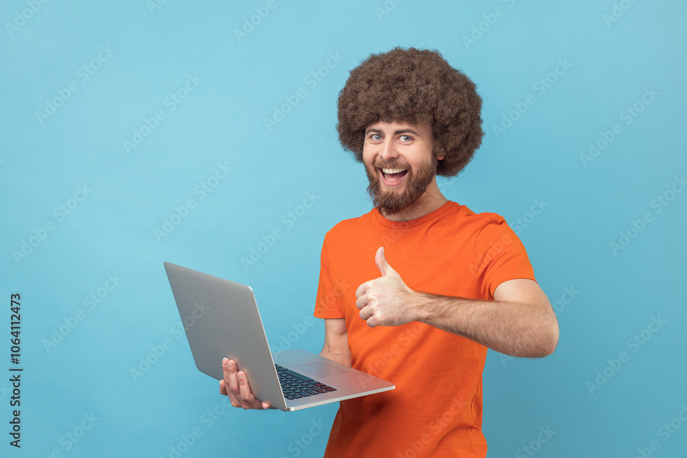 Man showing thumbs up standing and holding laptop, satisfied with teleworking, likes his job. Man showing thumbs up standing and holding laptop, satisfied with teleworking, likes his job.