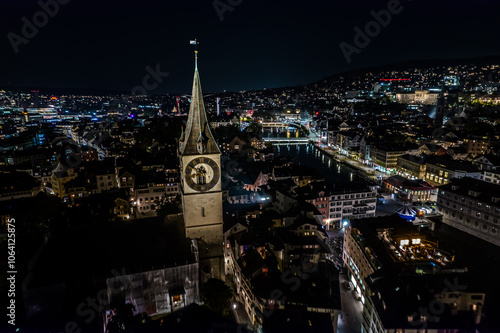Wall Mural Beautiful aerial view of the city of Zurich in Switzerland at night - the Limmat River and its iconic churches, buildings rivers and Clocks