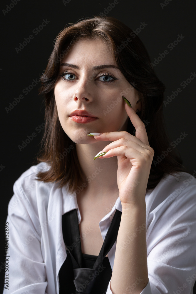 A young girl in a white shirt and black tie in the studio. A young girl in a white shirt and black tie in the studio.