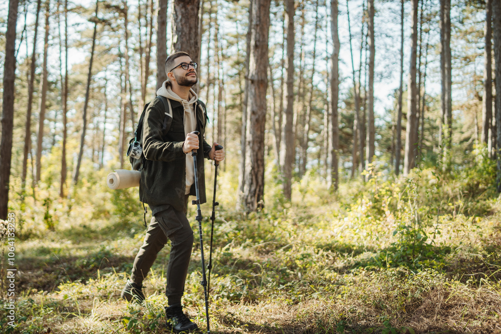 Young caucasian man hiking or trekking through the forest Young caucasian man hiking or trekking through the forest