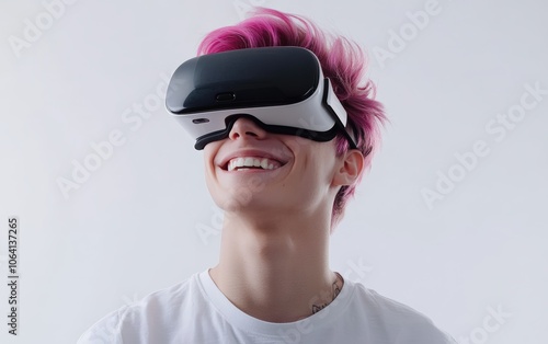 Smiling young pretty man with pink hair wearing a VR headset on a clean white background