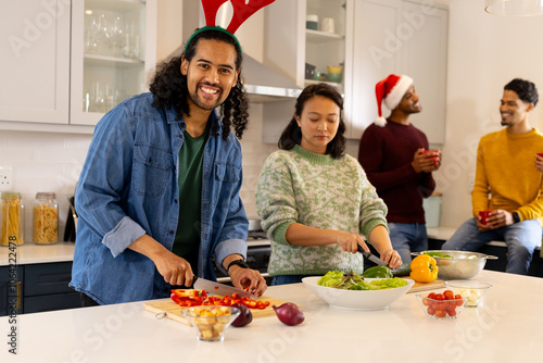 Christmas time, multiracial friends preparing festive meal in kitchen, at home