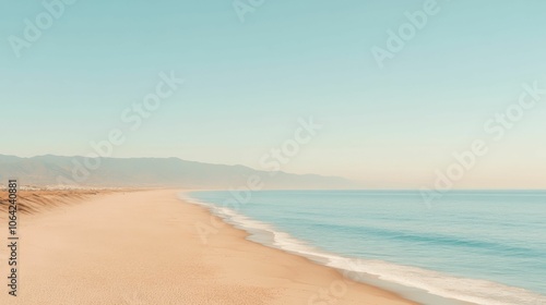 A beach with a clear blue ocean and a mountain in the background