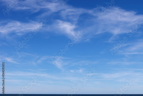 Beautiful blue sky over the sea with translucent, white, Cirrus clouds