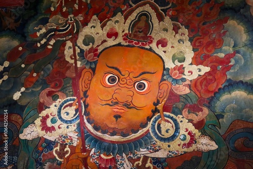 Vibrant traditional wall painting of a Tibetan deity adorned with intricate gold details and fierce expression, captured inside the historic Potala Palace in Lhasa, Tibet.