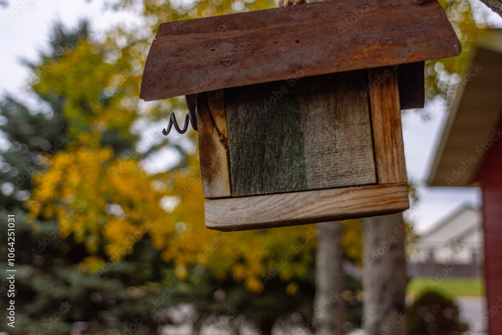Wooden birdhouse with vibrant trees in the background Wooden birdhouse with vibrant trees in the background