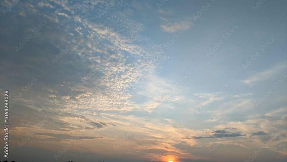 A dramatic sky with shades of gray, orange, and pink. The clouds are thick and appear to be moving quickly. The sky is divided into two distinct sections: gray area and a lighter, pink and orange area A dramatic sky with shades of gray, orange, and pink. The clouds are thick and appear to be moving quickly. The sky is divided into two distinct sections: gray area and a lighter, pink and orange area