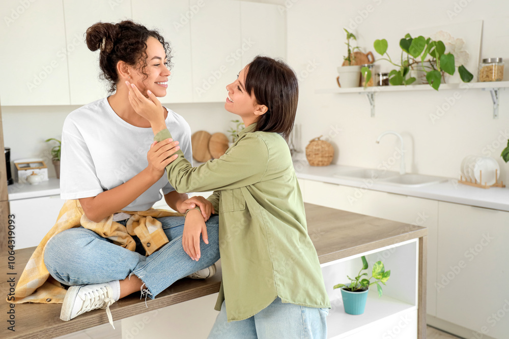 Young lesbian couple smiling in kitchen Young lesbian couple smiling in kitchen