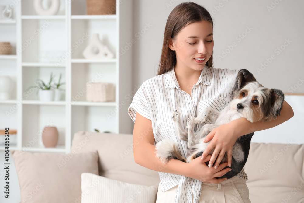 Obraz premium Young woman holding her Biewer Terrier dog at home