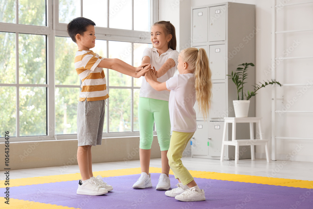 Fototapeta premium Cute little children putting hands together in gym