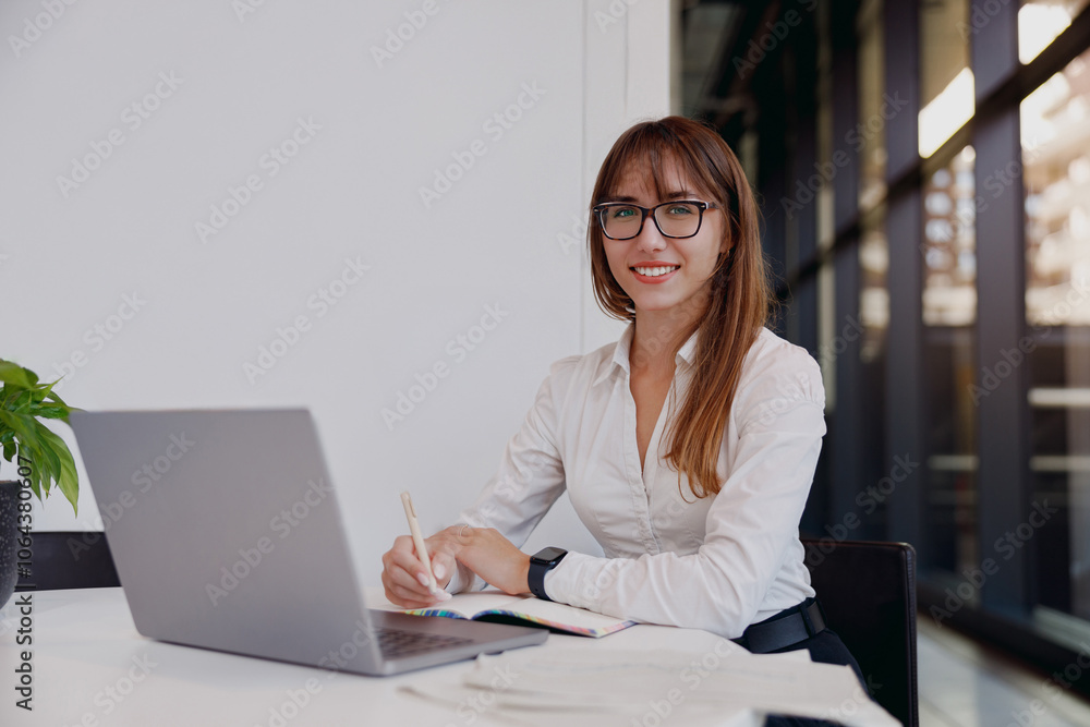 A highly focused professional woman vigorously typing on a sleek laptop in a chic and stylish office space A highly focused professional woman vigorously typing on a sleek laptop in a chic and stylish office space