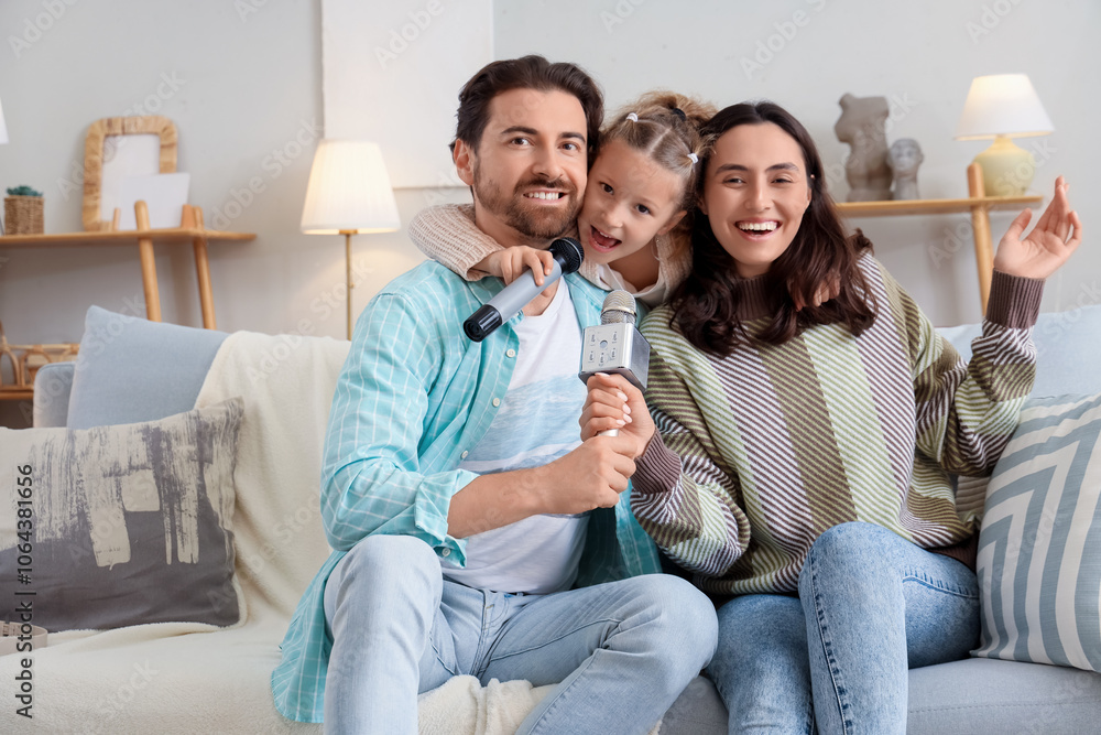 Happy family with microphones singing karaoke on sofa at home Happy family with microphones singing karaoke on sofa at home