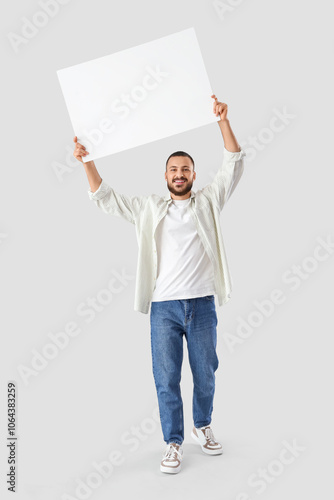 Young man with blank poster...