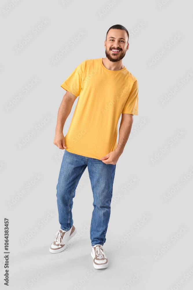 Fototapeta premium Young man in yellow t-shirt on light background