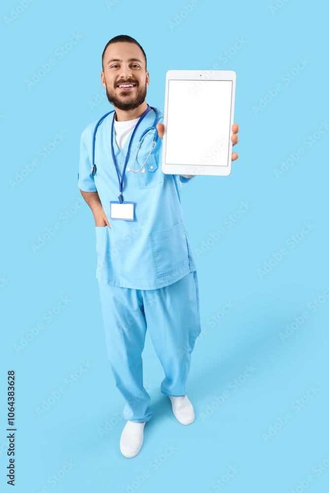 Male doctor with blank tablet computer on blue background Male doctor with blank tablet computer on blue background