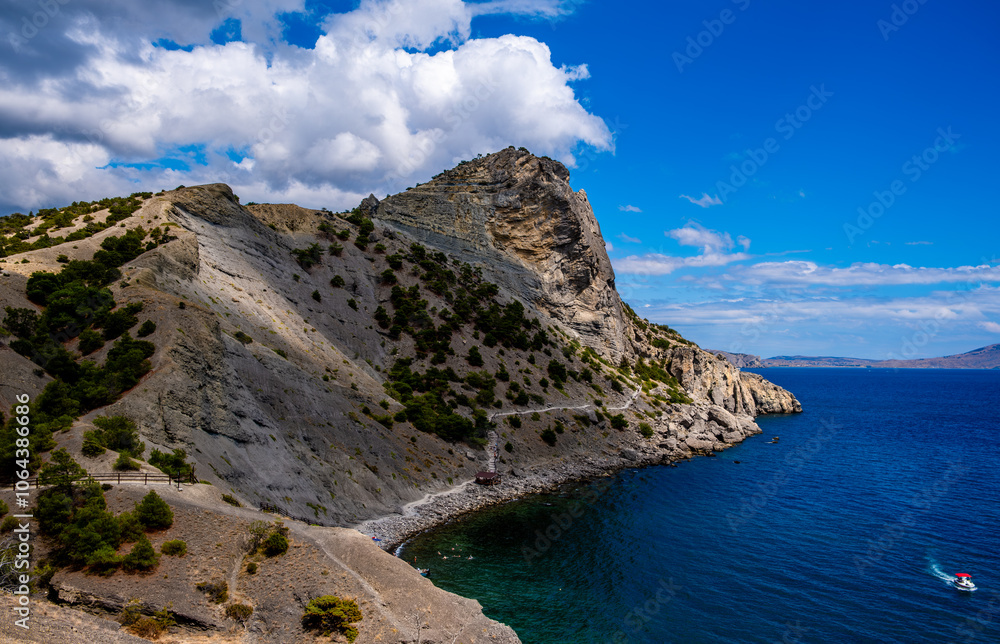 Rocks and mountains on the seashore against the background of clouds. Rocks and mountains on the seashore against the background of clouds.