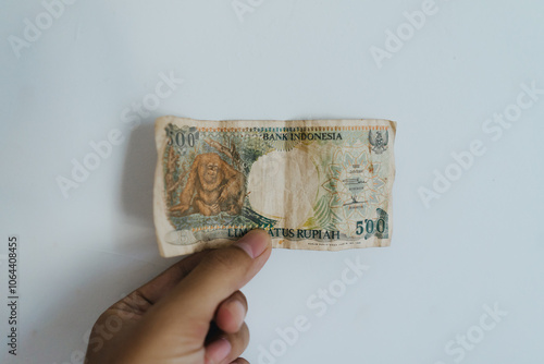 Hand holding old rupiah banknote with a nominal value of 500 photo