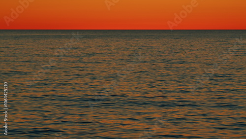 Golden Or Orange Sky In An Evening At Ocean. Orange Sun Set And Golden Sunshine Reflected On Sea. Slow motion. photo