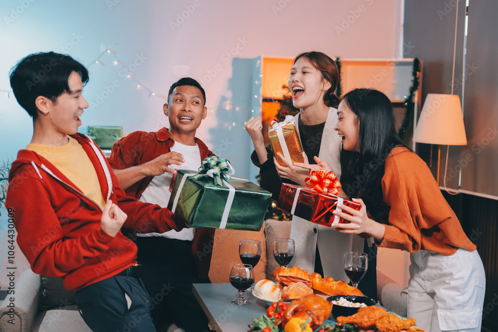 Group of young Asian man and women as friends having fun at a New Year's celebration, holding gift boxes standing by Christmas tree decoration, midnight countdown Party at home with holiday season. Group of young Asian man and women as friends having fun at a New Year's celebration, holding gift boxes standing by Christmas tree decoration, midnight countdown Party at home with holiday season.