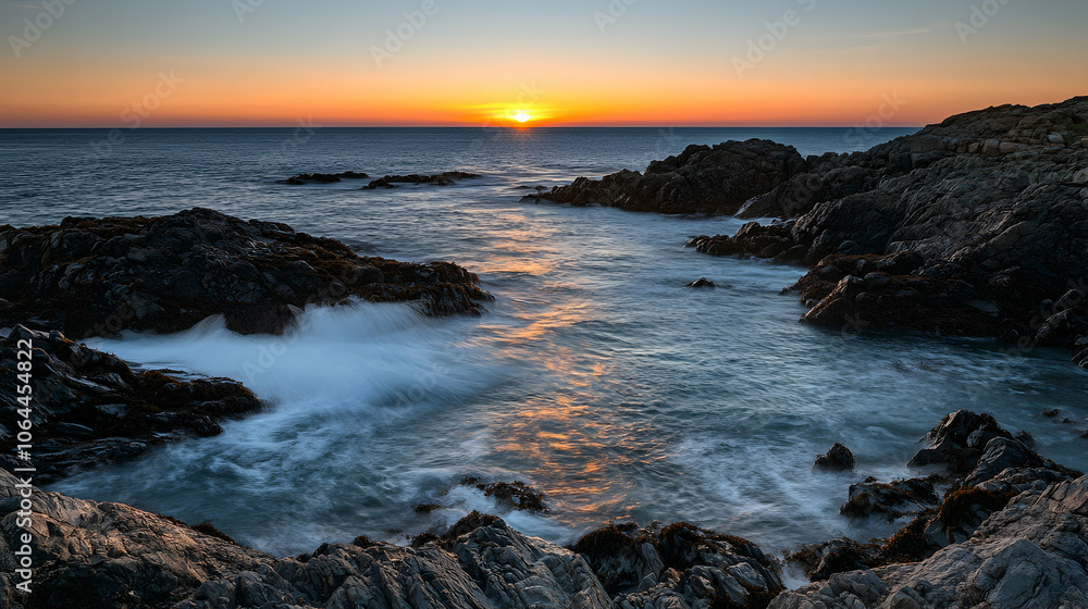 Sunset over a rocky coastline with waves crashing against the rocks. Sunset over a rocky coastline with waves crashing against the rocks.