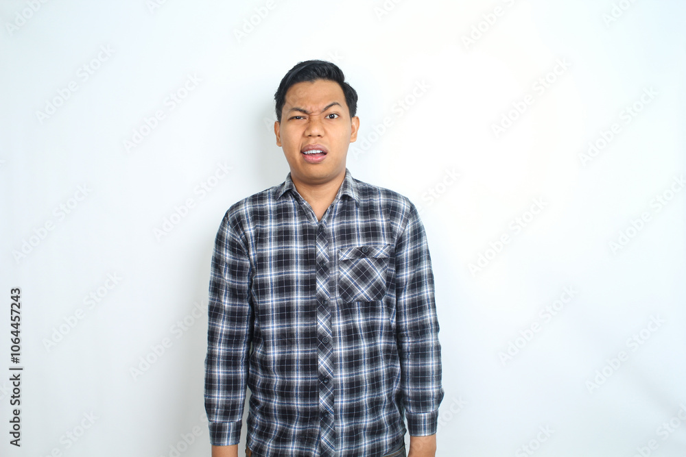attractive asian man wearing casual plaid shirt looks confused and puzzled isolated on white background