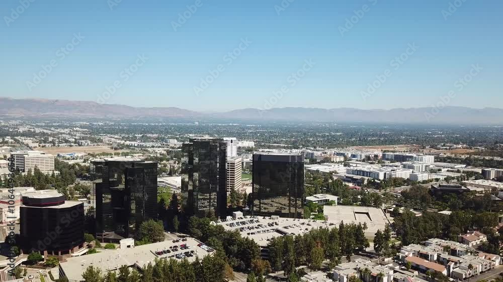 Aerial backwards shot of AIG Capital Service Towers in Woodland Hills District, of LA, USA. Sunny day over american neighborhood and mountains in background. Aerial backwards shot of AIG Capital Service Towers in Woodland Hills District, of LA, USA. Sunny day over american neighborhood and mountains in background.