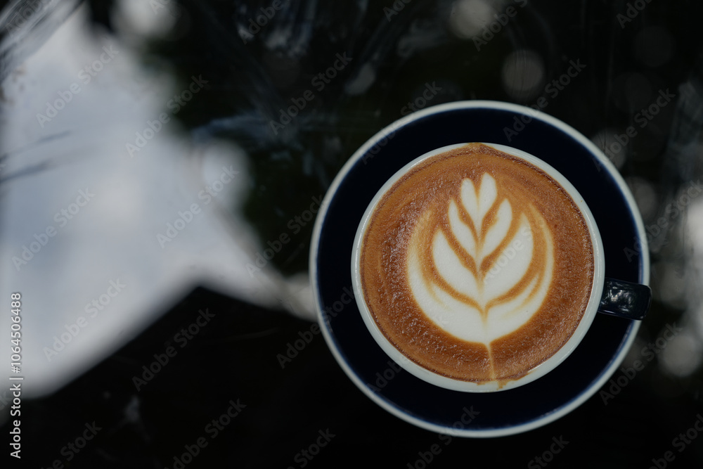 Hot coffee latte with latte art milk foam in a glass on a black background. Hot coffee latte with latte art milk foam in a glass on a black background.