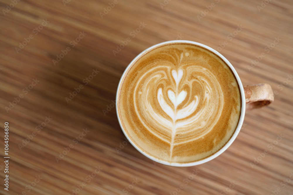Hot coffee latte with latte art milk foam in a glass on Wooden table. Hot coffee latte with latte art milk foam in a glass on Wooden table.