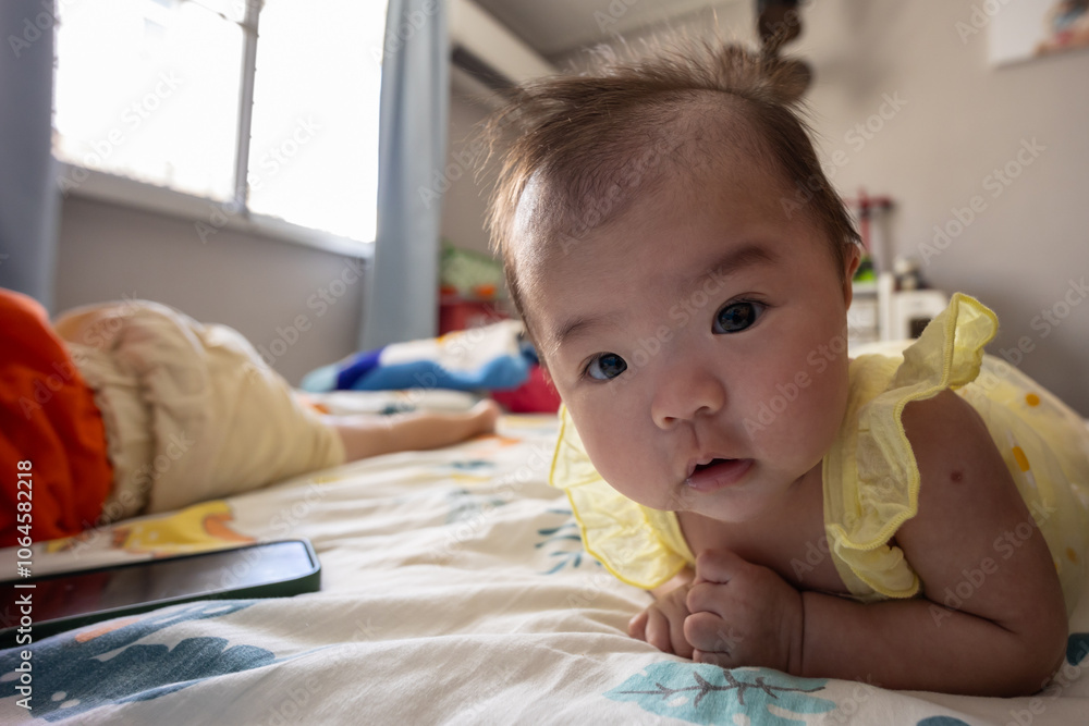 Happy Smiling face Asian Chinese baby girl during lying on bed. Happy Newborn child relaxing in bed Happy Smiling face Asian Chinese baby girl during lying on bed. Happy Newborn child relaxing in bed
