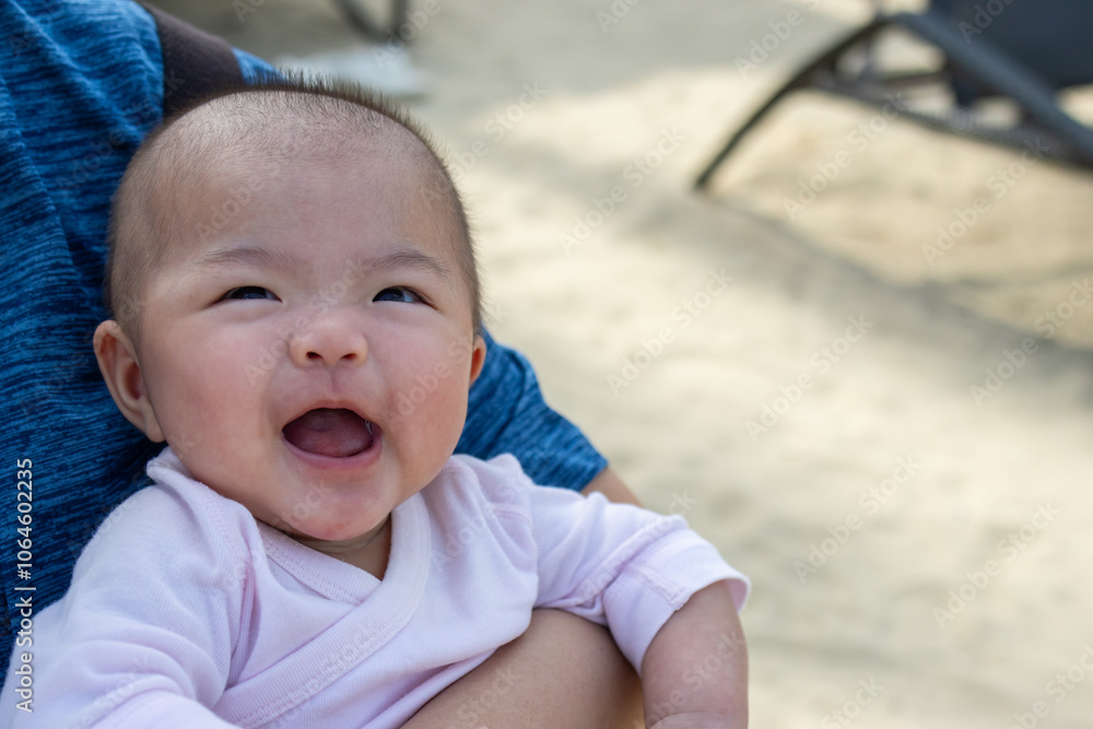 Smiling asian baby looking happy being held by parent Smiling asian baby looking happy being held by parent