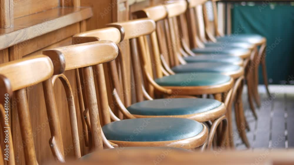 A Row of Beautiful Wooden Chairs Enhanced with Green Cushions in a Warm and Cozy Setting A Row of Beautiful Wooden Chairs Enhanced with Green Cushions in a Warm and Cozy Setting