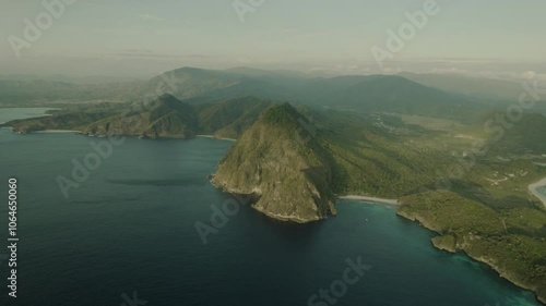 Pantai Lawar beach in Sumbawa, Indonesia, with green cliffs and pristine waters, sweeping grand views of stunning landscape from aerial perspective photo