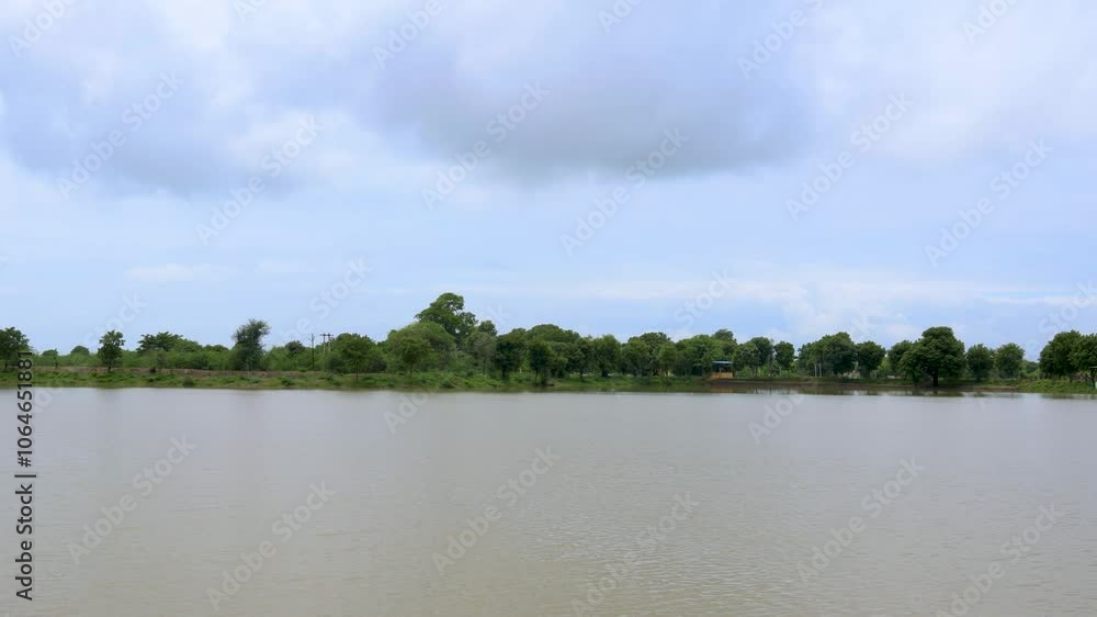 Flooded River with Muddy Water and Bright Sky Background Flooded River with Muddy Water and Bright Sky Background