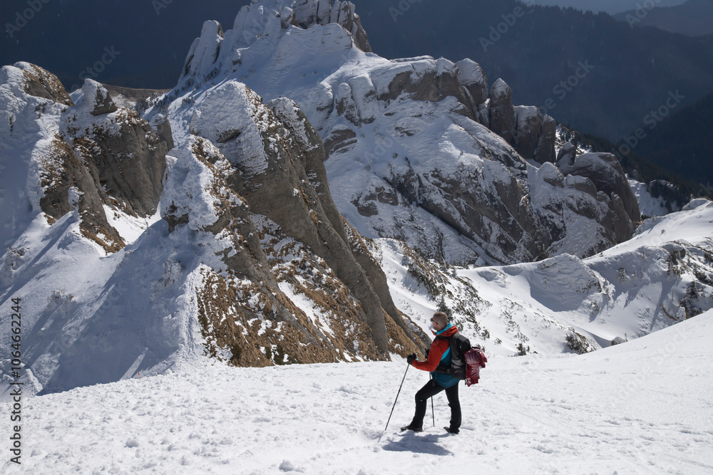 A lone hiker gazing at a majestic, snow-covered mountain peak A lone hiker gazing at a majestic, snow-covered mountain peak