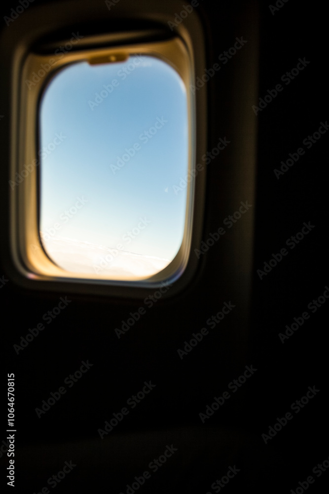 View through an aircraft window of sky and light clouds View through an aircraft window of sky and light clouds