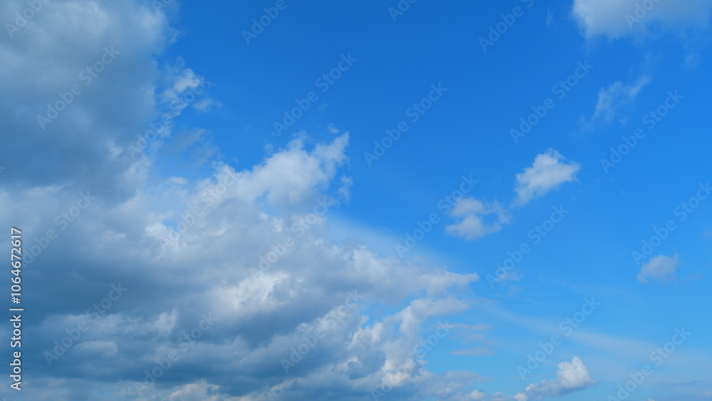 Obraz premium Dramatic moving white cumulus and cirrocumulus clouds or puffy fluffy cloudscape on beautiful sunny blue sky. Time lapse.