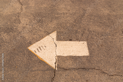 White arrow on cracked pavement photo