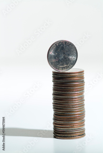 High angle close up of a stack of US quarters, silver coloured coins with one on end photo