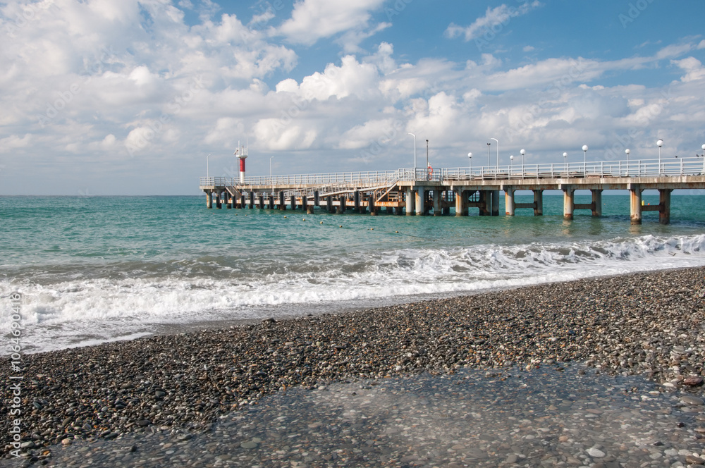 Morning view of Black Sea coast with pier and beacon near pebble beach, Dagomys, Sochi, Russian Federation Morning view of Black Sea coast with pier and beacon near pebble beach, Dagomys, Sochi, Russian Federation