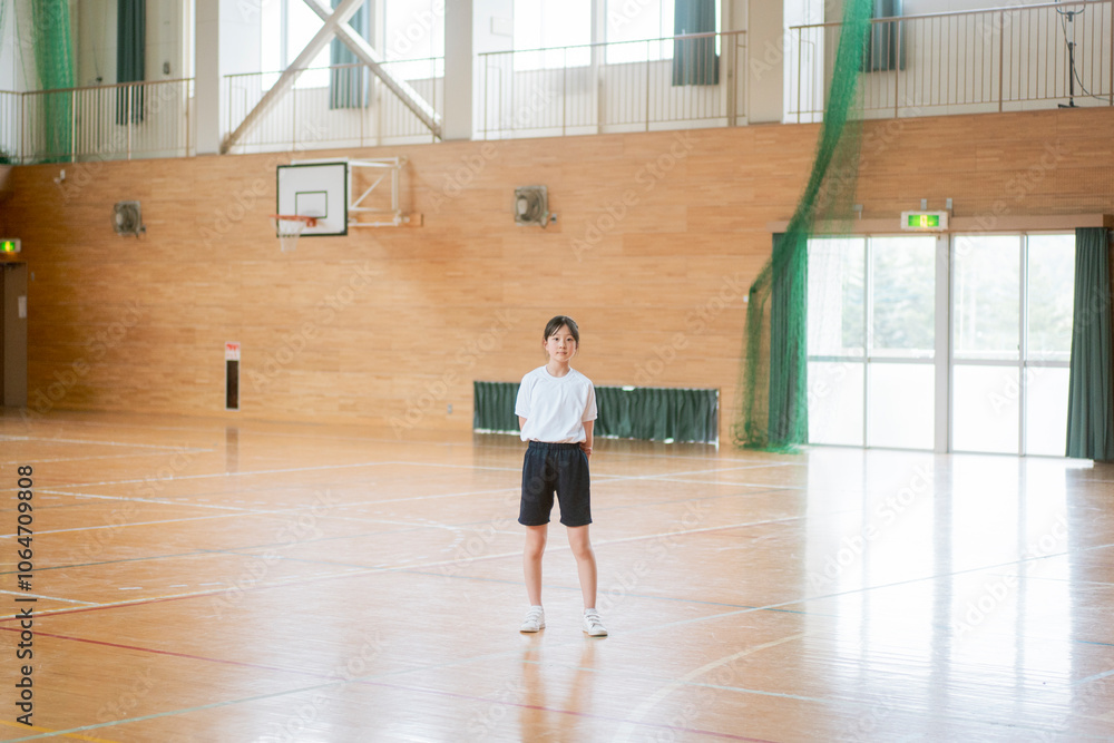 学校の体育館の中で立っている女の子 学校の体育館の中で立っている女の子