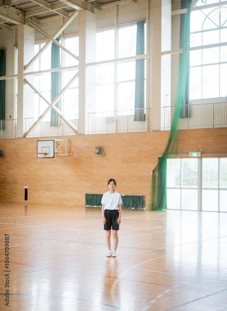学校の体育館の中で立っている女の子 学校の体育館の中で立っている女の子