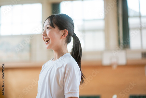 笑っているポニーテールの女性生徒の横顔