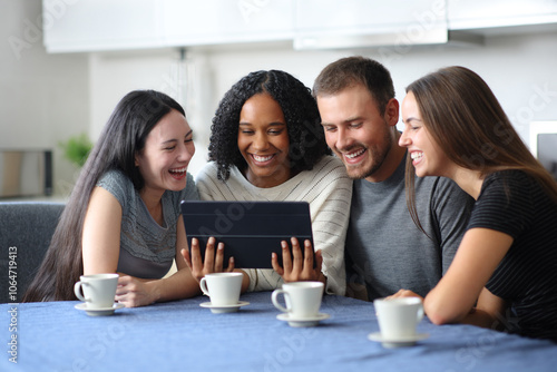 Four interracial friends watching video on tablet