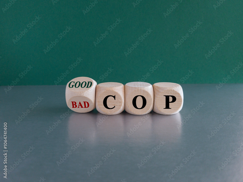 Turned wooden cubes and changed the expression Bad cop to Good cop, or vice versa. Beautiful green background, grey table.