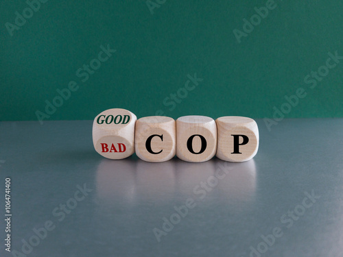 Obraz na płótnie Turned wooden cubes and changed the expression Bad cop to Good cop, or vice versa. Beautiful green background, grey table. w salonie