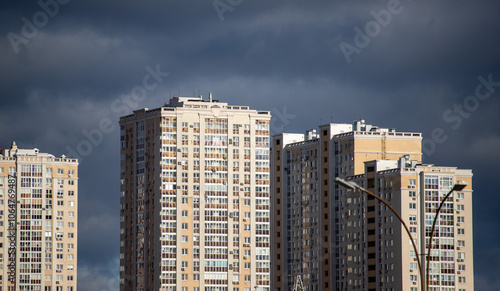 A city skyline with tall buildings and a cloudy sky