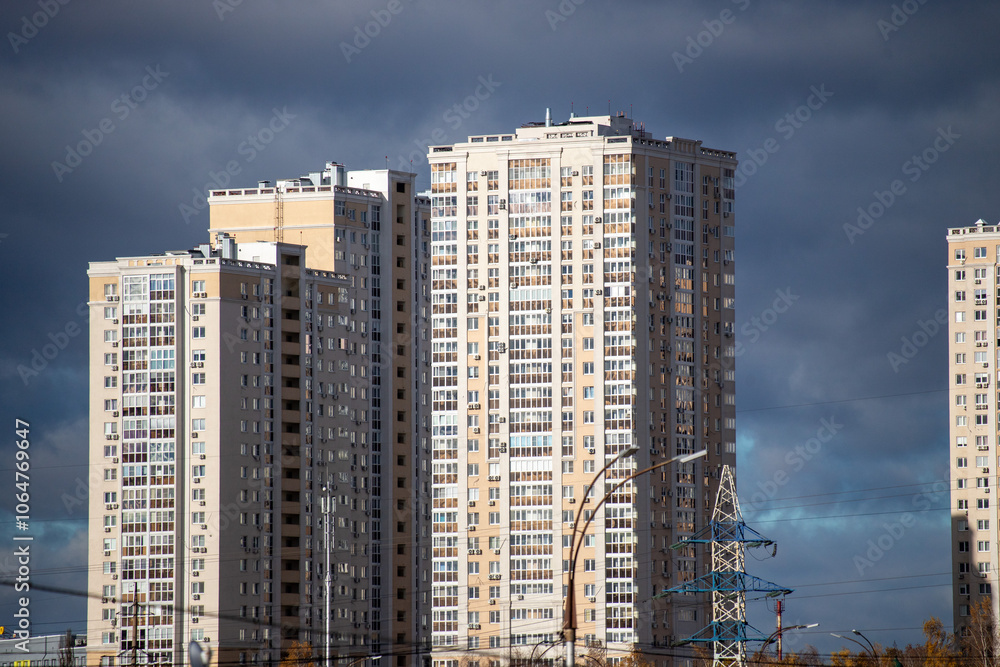 A row of tall buildings with a cloudy sky in the background A row of tall buildings with a cloudy sky in the background